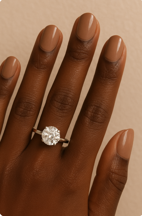 Black woman's hand with round cut engagement ring and short oval shaped nails