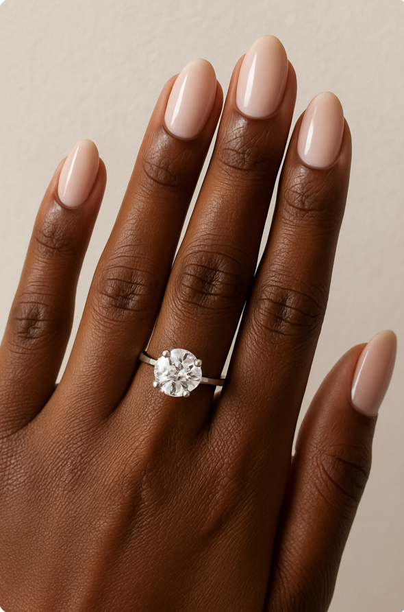 Black woman's hand with round cut engagement ring and oval shaped nails