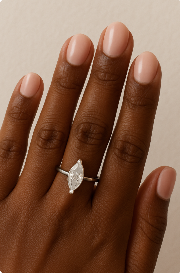Black woman's hand with marquis engagement ring and short oval shaped nails